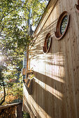 Wooden façade of tinz house with round porthole windows