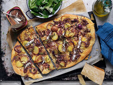 Pizza with potatoes, cheese, herbs red onions and anchoies