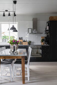 Dining table in large kitchen-dining room in Scandinavian country-house style