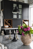 Flowers in rustic vase on table in country-house kitchen