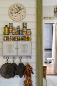 Old tin cans and spices on small wall-mounted cabinet
