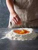 Preparing pasta dough: Mix raw eggs in a flour well