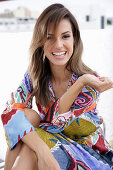 A young woman wearing a brightly patterned summer dress