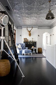 Studio lamp and ladder in open-plan interior with silver stucco ceiling