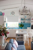 White open-plan kitchen with splashback of sky-blue mosaic tiles