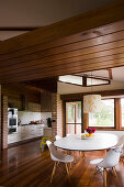 Open-plan kitchen and dining area below suspended wooden ceiling