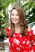 A young woman wearing a red floral-patterned Carmen blouse