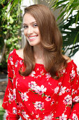 A young woman wearing a red floral-patterned Carmen blouse