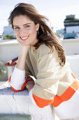 A young woman wearing a light knitted jumper