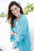 A young woman wearing a blue shirt blouse