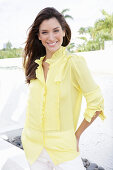 A blonde woman wearing a frilly yellow blouse