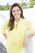 A blonde woman wearing a frilly yellow blouse