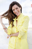 A blonde woman wearing a frilly yellow blouse