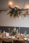 Gedeckter Hochzeitstisch, darüber Gesteck aus Trockenblumen im Raum mit Industrie-Flair