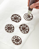 Schokoladenverzierung auf Backpapier spritzen