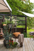 Planters and vintage-style accessories on cosy terrace in garden