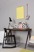 Picture frame, cards and lamp on desk with black wooden chair