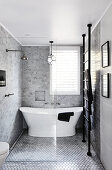 Freestanding bathtub in elegant bathroom in grey, black and white