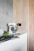 Mixer on kitchen counter against wood and concrete walls
