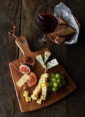 A rustic cheese platter and a glass of red wine