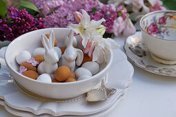 Porcelain Easter bunnies between marzipan eggs in bowl