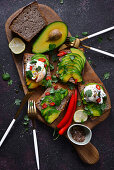 Toasts with avocado and poached egg on a wooden board