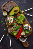 Toast mit Avocado und pochiertem Ei auf Holzbrett