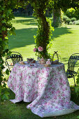 Romantically set tea table in summery château garden