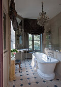 Bad im französischen Stil mit freistehender Badewanne, Kronleuchter und Vorhängen