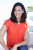 A mature brunette woman wearing a red blouse