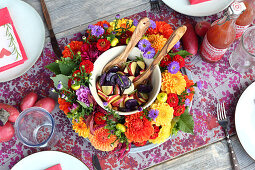 Bunter Kartoffelsalat in einem Blumenkranz auf gedecktem Tisch