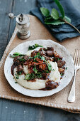 Rotweinente mit weisser Polenta, Kohlchips und knusprigem Speck