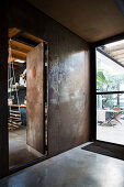 Foyer with vintage-style wall, open door and concrete floor