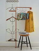 Arrangement of coat hangers bent into various shapes decorating wall and used as magazine holders