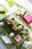 Flowers on table covered in artificial grass on terrace