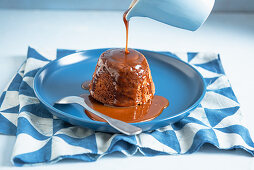 Hot toffee pudding with toffee sauce poured