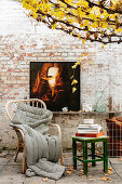 Seating area with photograph on brick wall below autumnal vines