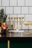 Goldenes Cocktail-Besteck an einer Hänge-Aufbewahrung in der Küche