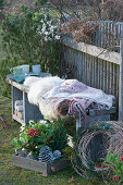 Bench with fur and blanket as a seat on the garden fence