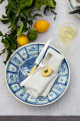 Table setting decorated with lemon cookie and sprig of lemons