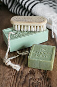 Bars of green soap and brush on wooden board
