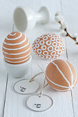 Blown brown eggs decorated with white patterns
