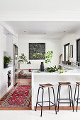 Marble breakfast bar and bar stools in open-plan kitchen