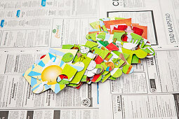 Large jigsaw pieces spread out on newspaper
