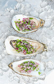 Opened oysters with chives and onions on ice