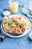 Vegeterian eggplant stuffed with bell pepper, tomatoes and parsley, served with bulgur