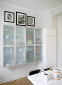 Crockery in wall-mounted cabinets with frosted glass doors in kitchen