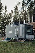 Tiny house with corrugated metal façade on edge of woods