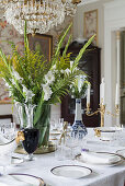 Bouquet of white gladiolas, ferns and goldenrod on set table