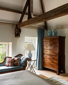 Alte Kommode im klassischen Schlafzimmer mit Holzbalken